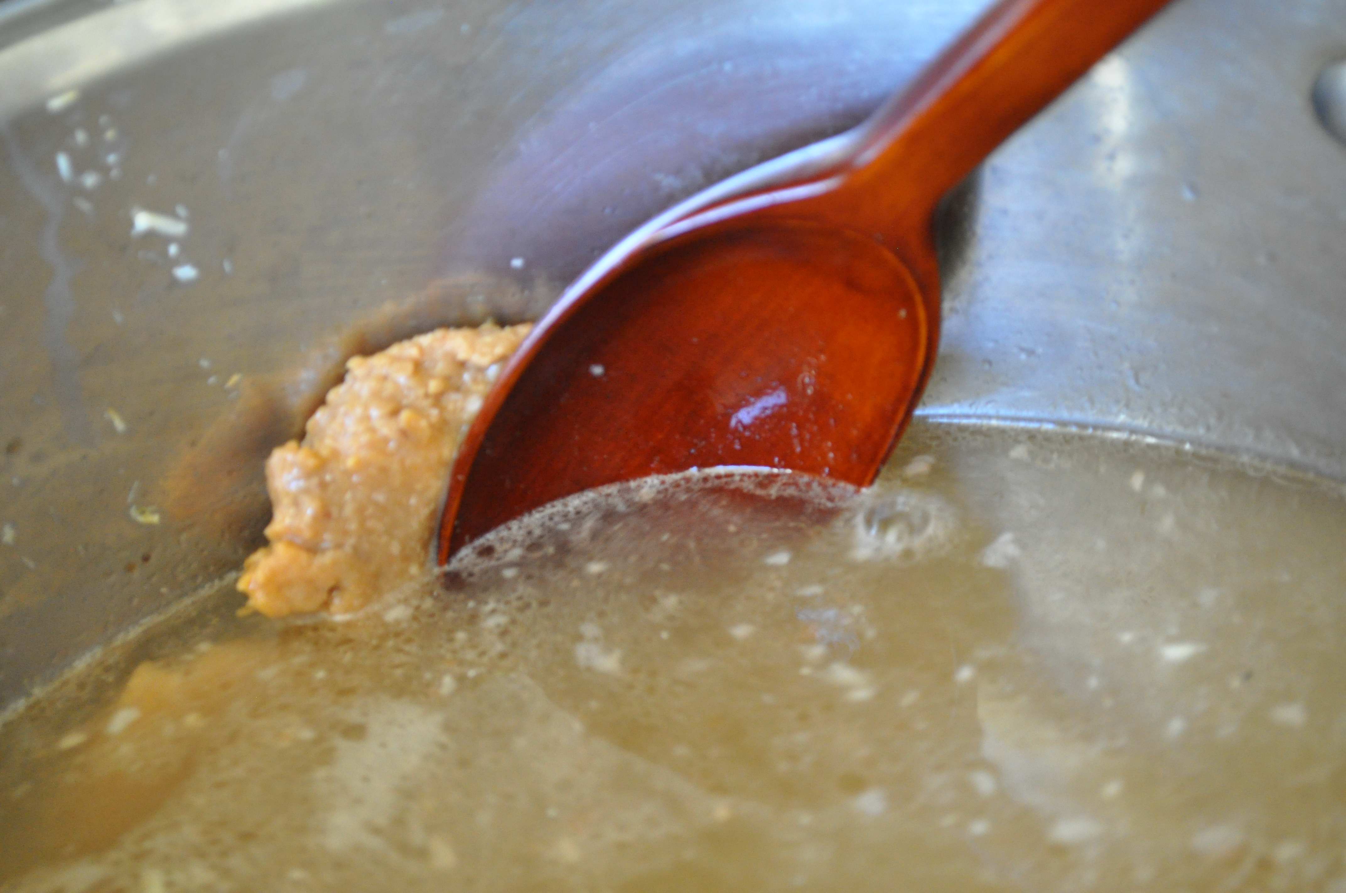 mixing soybean paste into soup