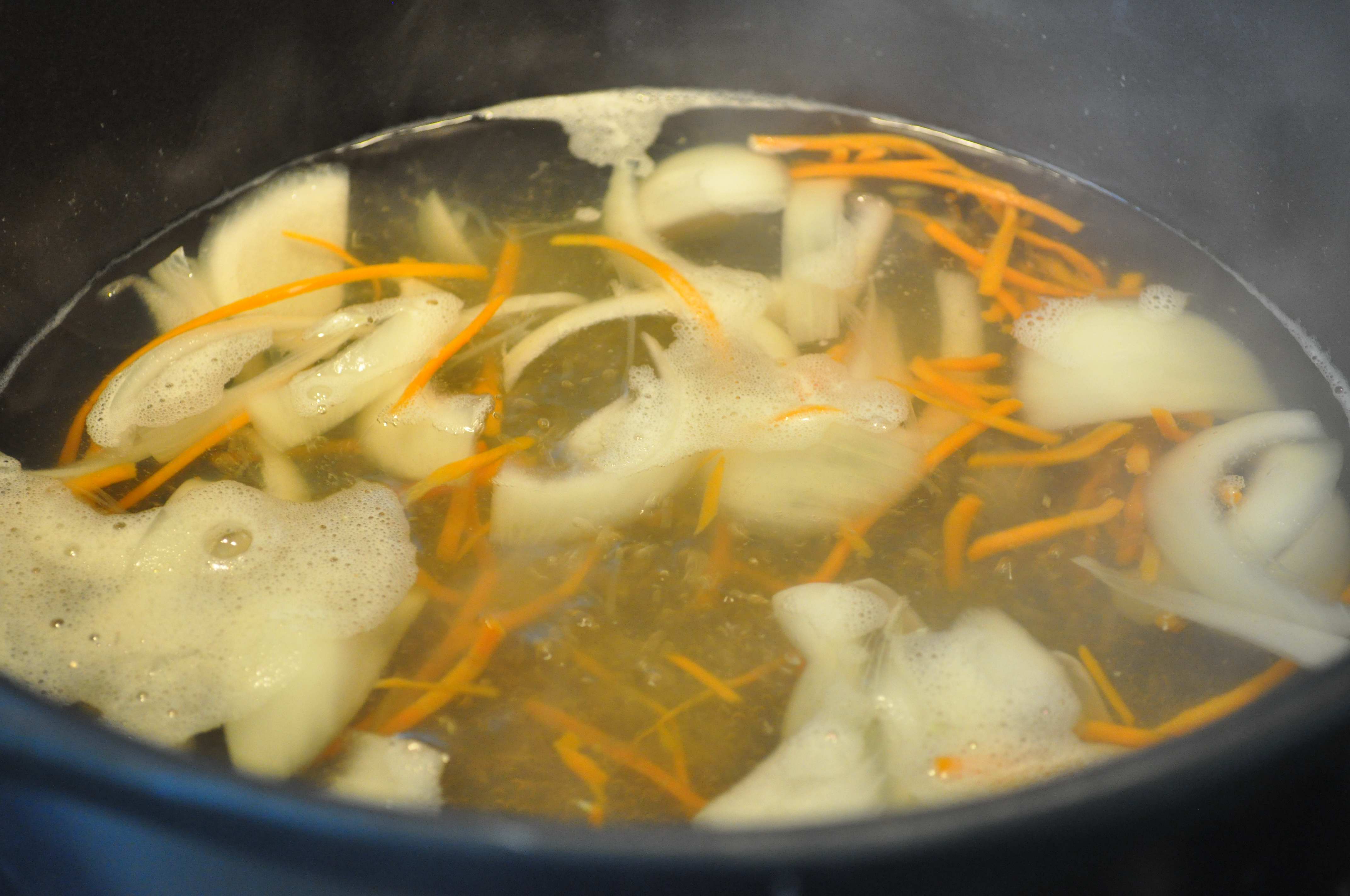 soup stock boiling with onions and carrots for rice cake soup
