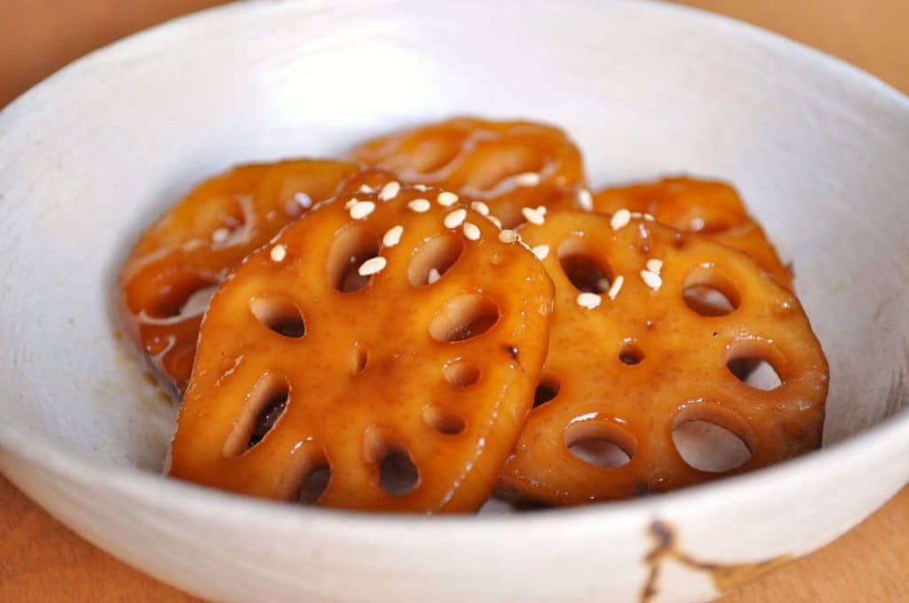 sweet and salty glazed lotus roots with sesame seeds garnish