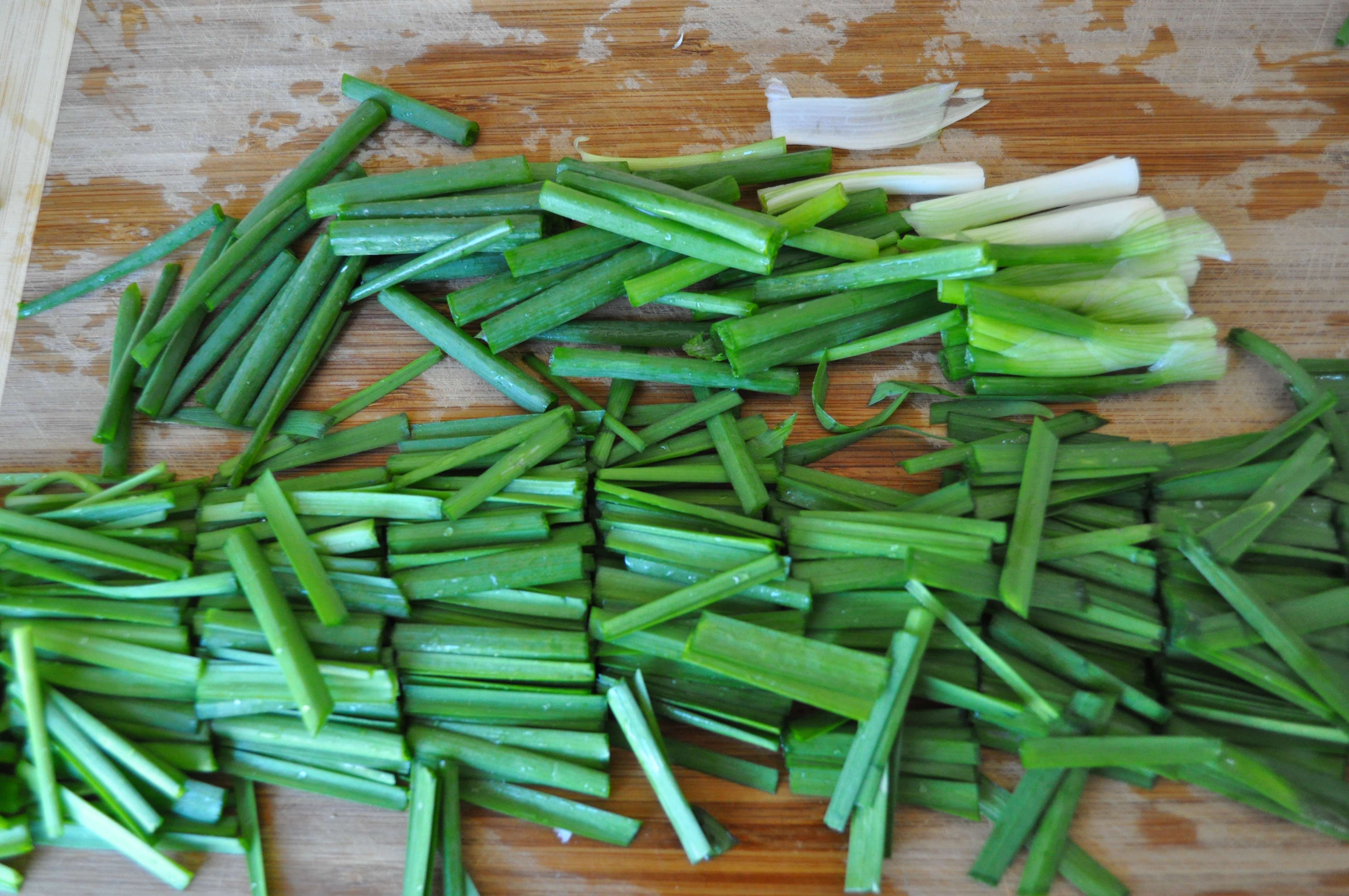 green onions and chives cut into lengths on cutting board