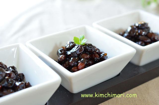 3 square bowls with glazed black beans with green leaf garnish