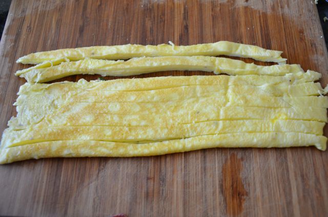 egg jidan sliced lengthwise for gimbap on cutting board