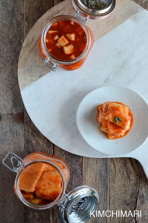 Radish Kimchi (Seokbakji) in glass jars and plate - top view