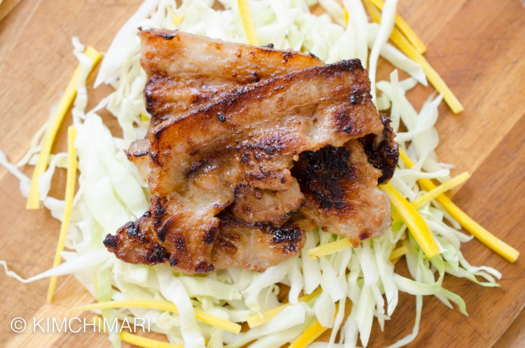 Grilled miso pork belly served on cabbage slaw and green onions