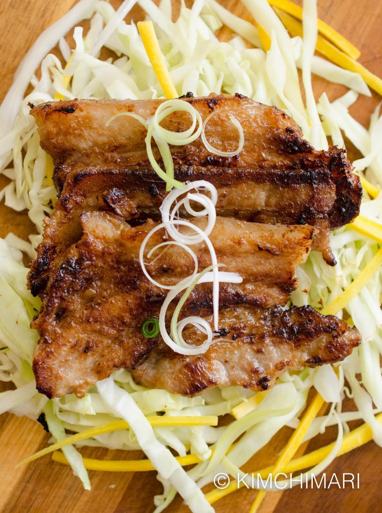 Grilled miso pork belly served on cabbage slaw and green onions