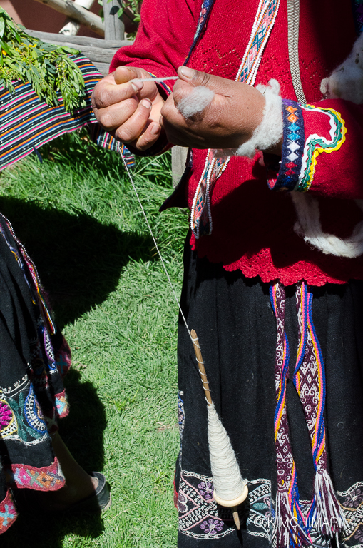 Peruvian lady pinning Alpaca hair into yarn