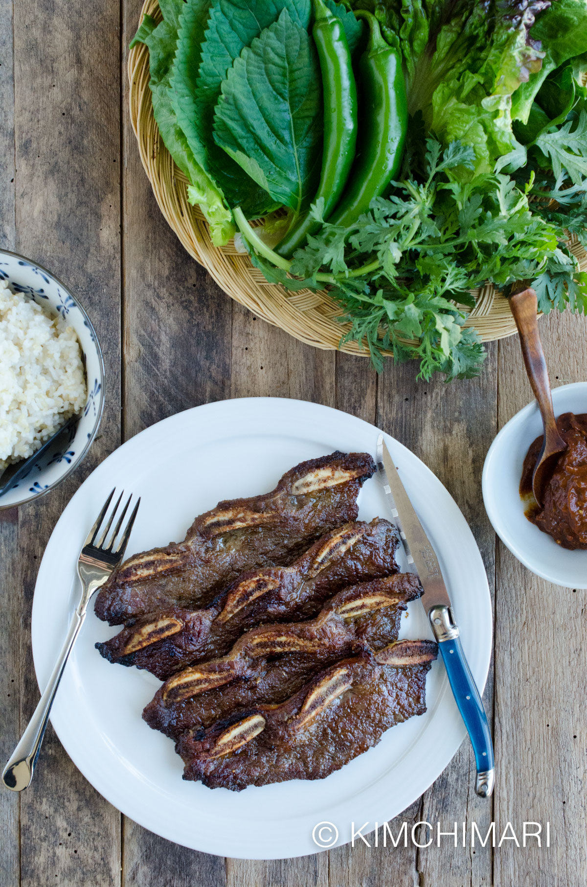 grilled short kalbi ribs on plate with side of ssamjang, ssam greens and rice