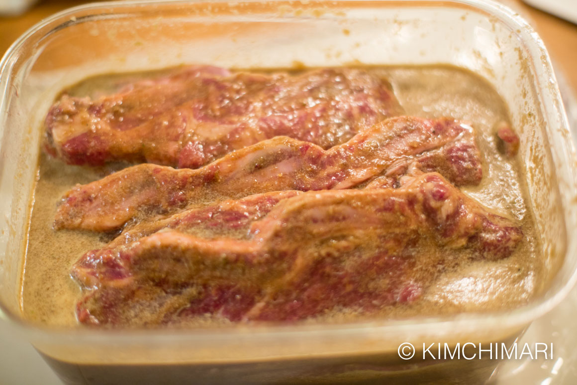 short ribs with marinade in a plastic container