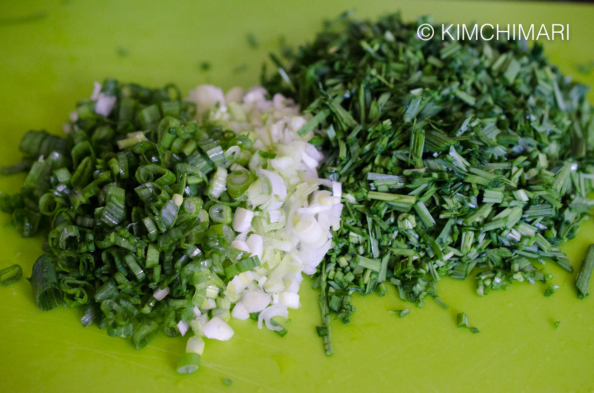 chopped chives and green onions on cutting board