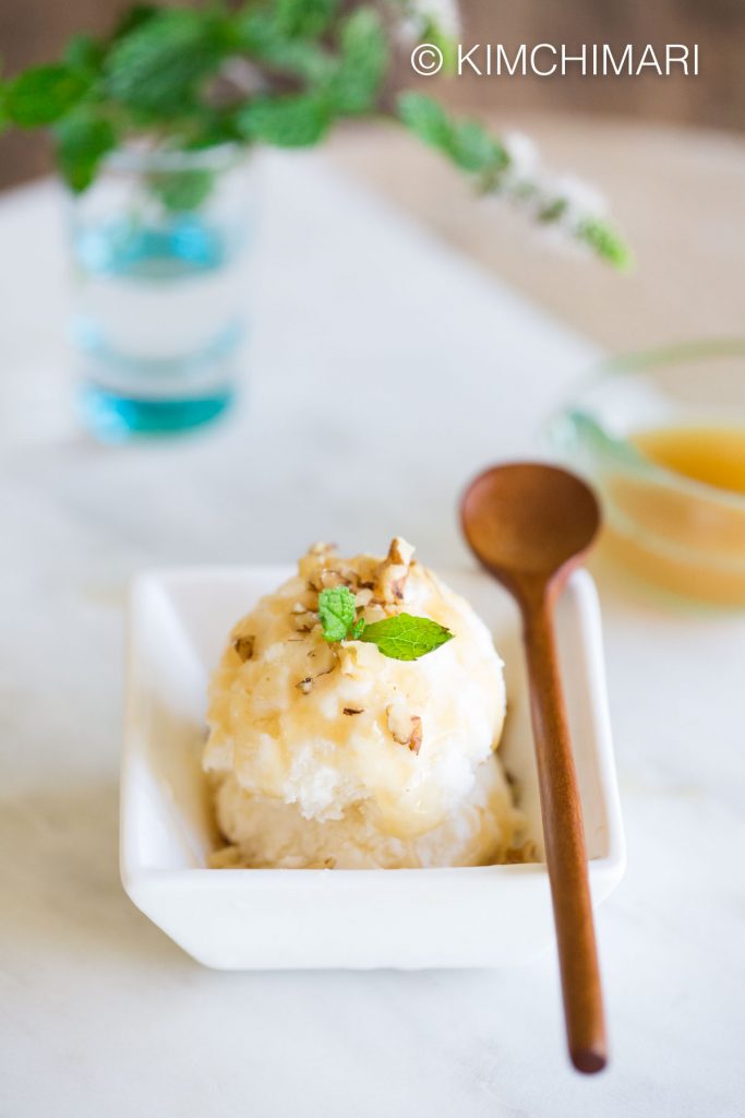 Makgeolli Ice Cream served with chopped walnuts, makgeolli syrup and mint leaves