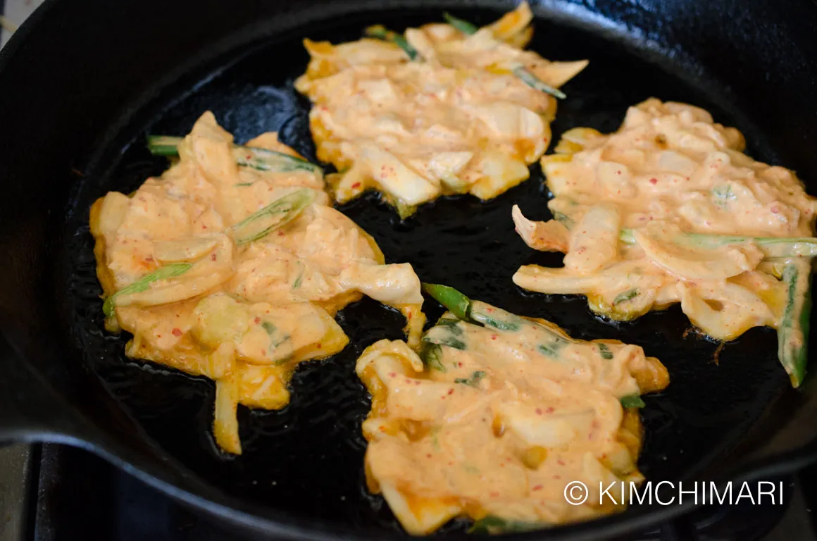 Kimchi Pancakes frying in cast iron pan