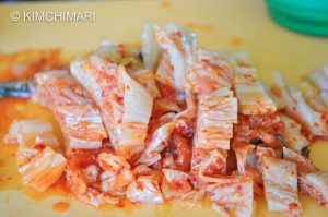 Cut kimchi on yellow cutting board
