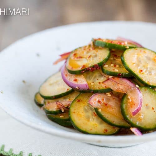Spicy Asian Cucumber Salad with onions finished and shown in white bowl