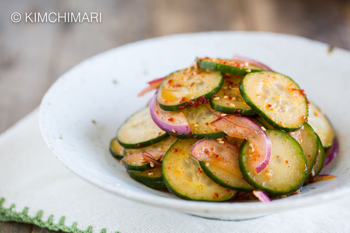 Spicy Asian Cucumber Salad with onions finished and shown in white bowl