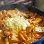 Side view of Budae Jjigae cooked in pot with steam escaping