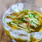 Korean Cold Cucumber Soup in bowl with cucumber in soy sauce broth with ice