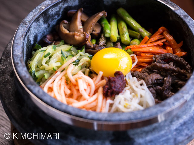 Bibimbap in Stone Pot with vegetable and meat toppings and egg yolk
