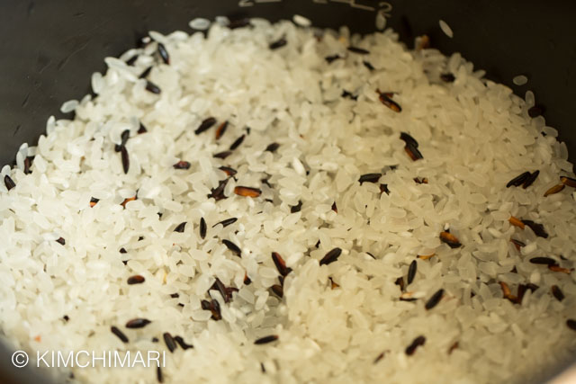 Uncooked black and white rice in pot