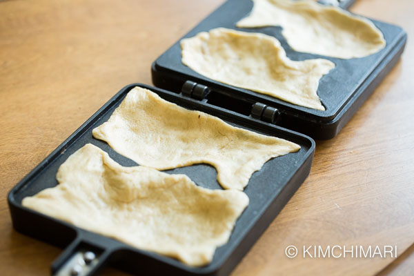 All 4 bungeoppang pan molds covered with cut dough sheets