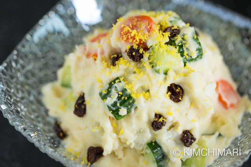 Korean Potato Salad in glass bowl dotted with Raisins