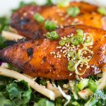 baked chicken breast on top of kale salad mix, topped with green onions