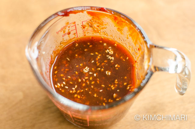 a glass measuring cup with mixed gochujang marinade inside