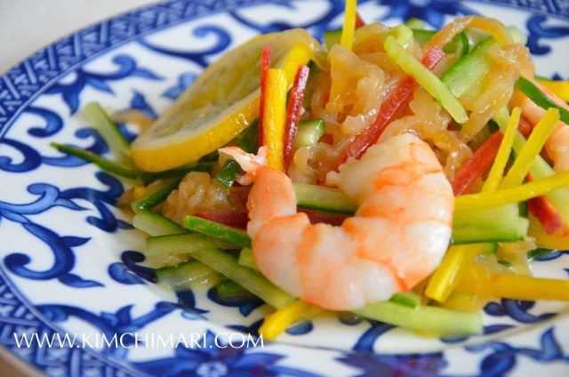 jellyfish salad with cucumbers lemon shrimp served on plate with blue designs