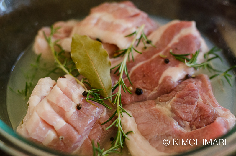 samgyeopsal marinating in white wine with herbs and peppercorns