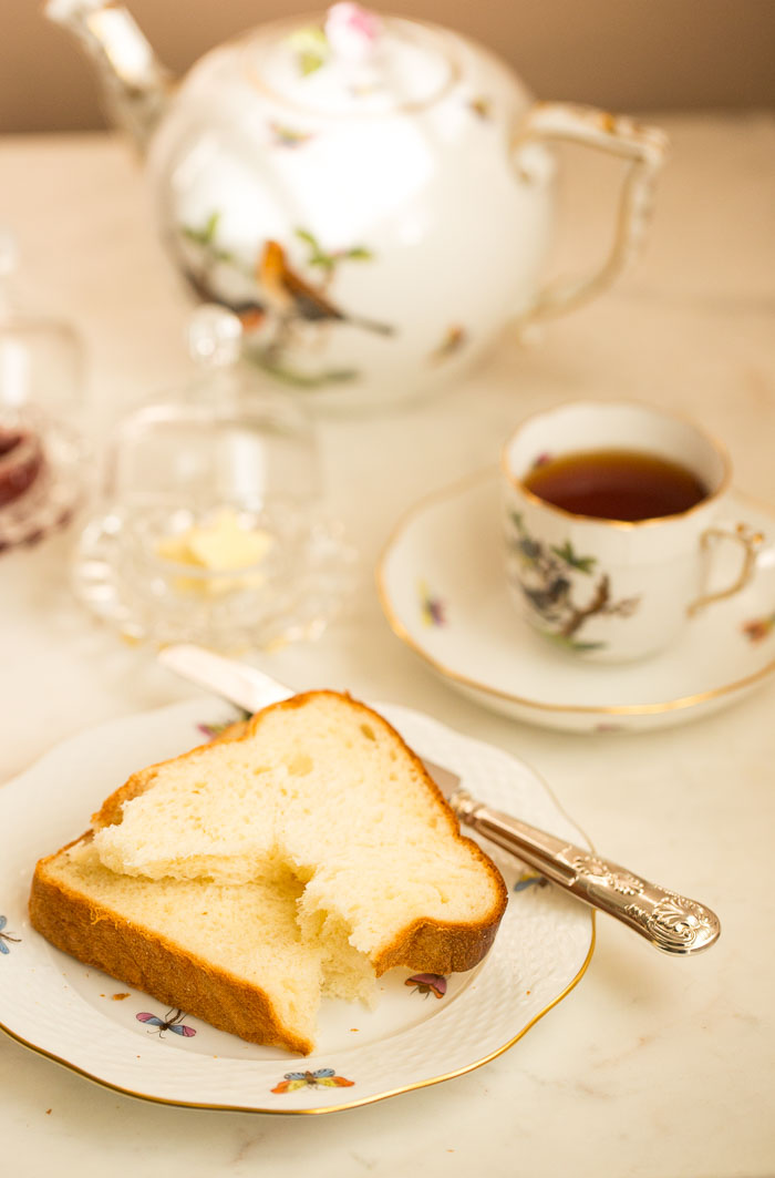 tea served in cup with slice of bread, butter and jam