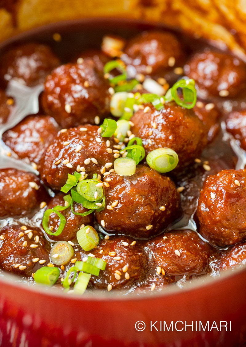gochujang meatballs finished in pot topped with green onions and sesame