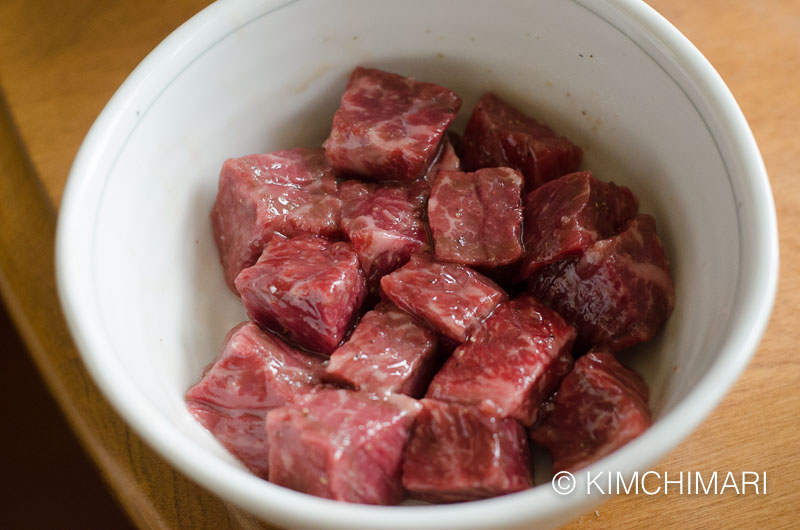 marinated steak cubes in white bowl