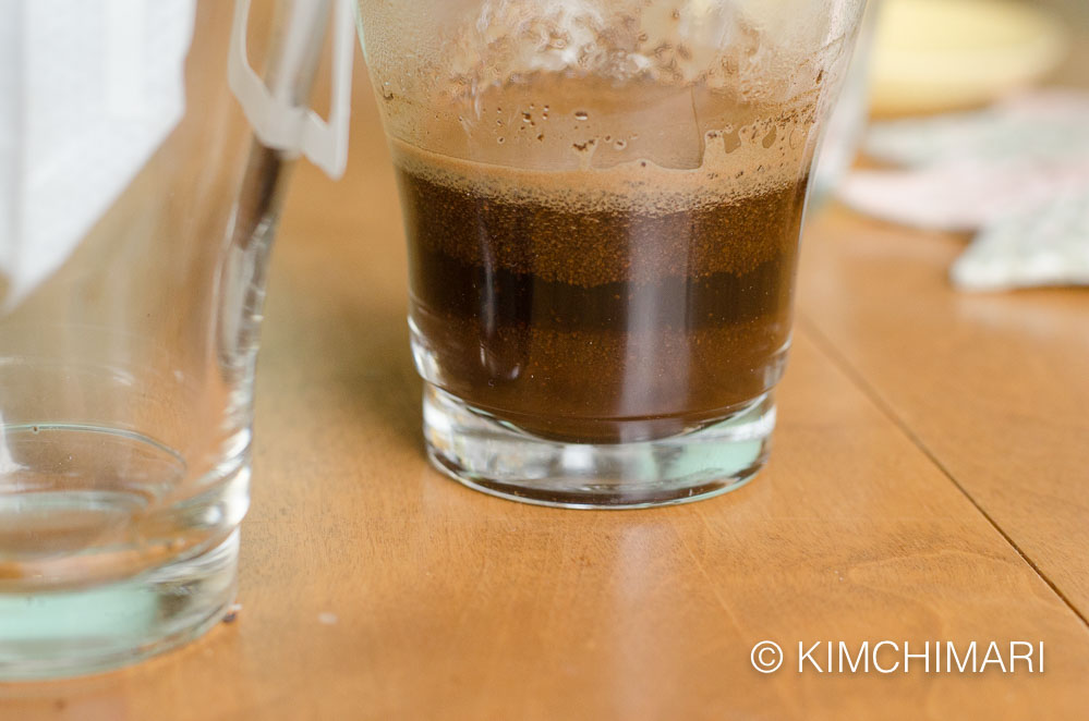 coffee grounds mixed with water in glass cup