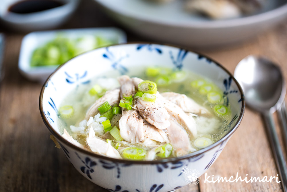 soup in bowl with chicken meat, rice and chopped green onions on top