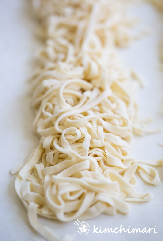 a long pile of knife cut noodles on white platter