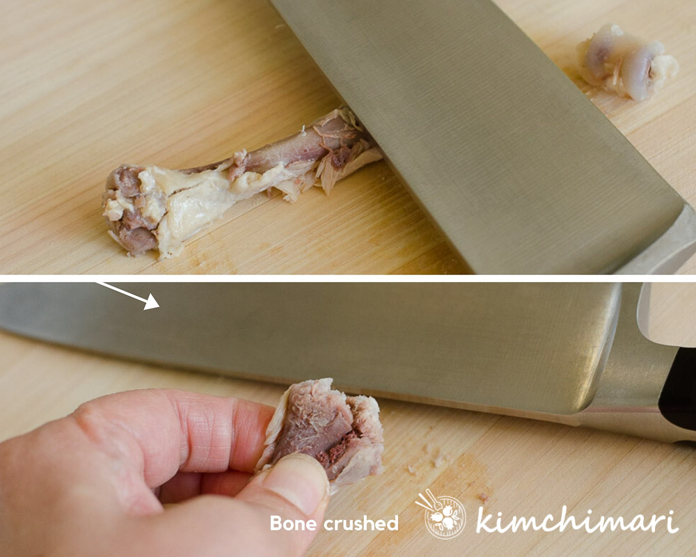 crushing bone with side of knife on cutting board