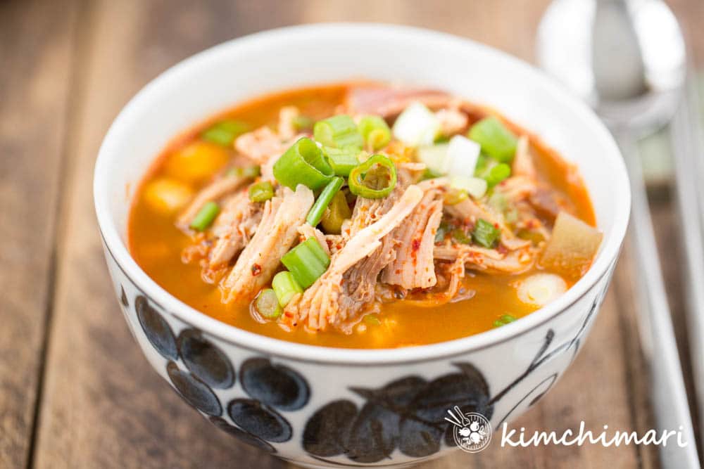 spicy turkey soup in bowl with rice and spoon on the side