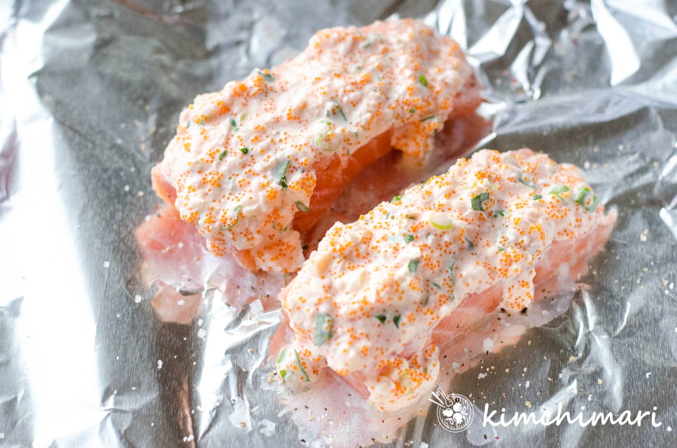 small pieces of salmon covered with sauce on tin foil