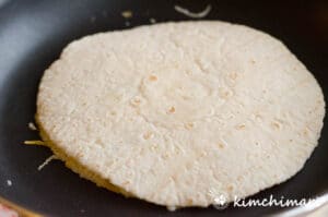 tortilla covered on top in frying pan