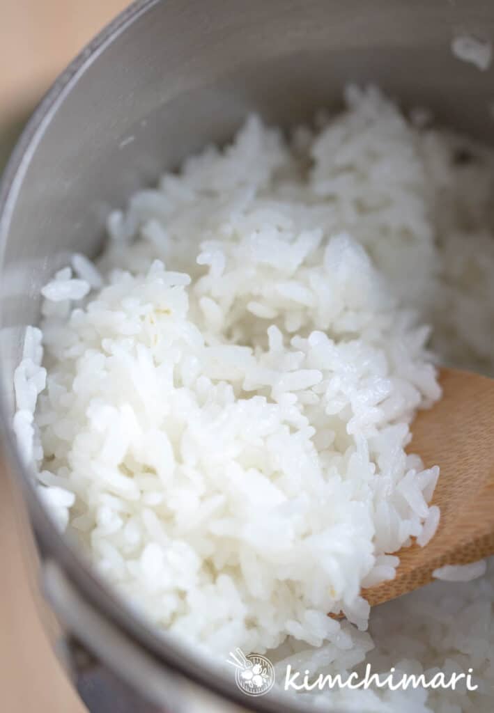 rice in stainless pot scooped up with spatula