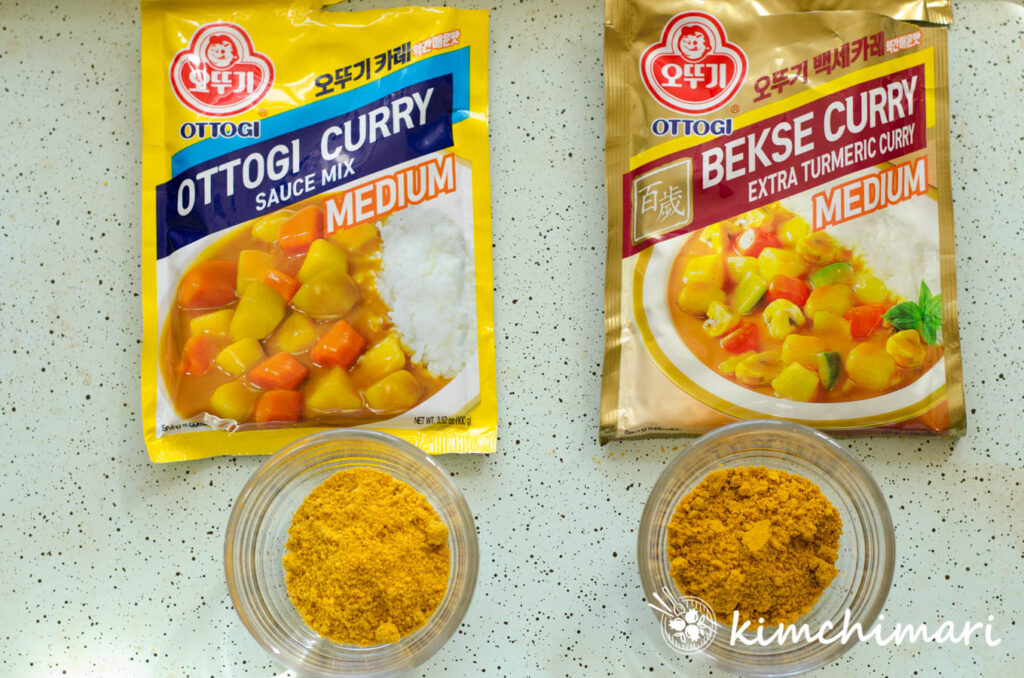 2 side by side packages of Ottogi Korean Curry Rice Mixes - regular and extra turmeric