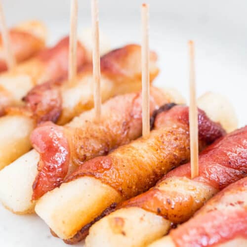 bacon wrapped rice cakes put in a row on a plate