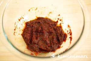 red chili powder mixed with soy sauce in glass bowl