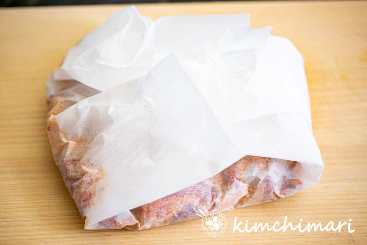 marinated pork belly wrapped in parchment paper for freezing