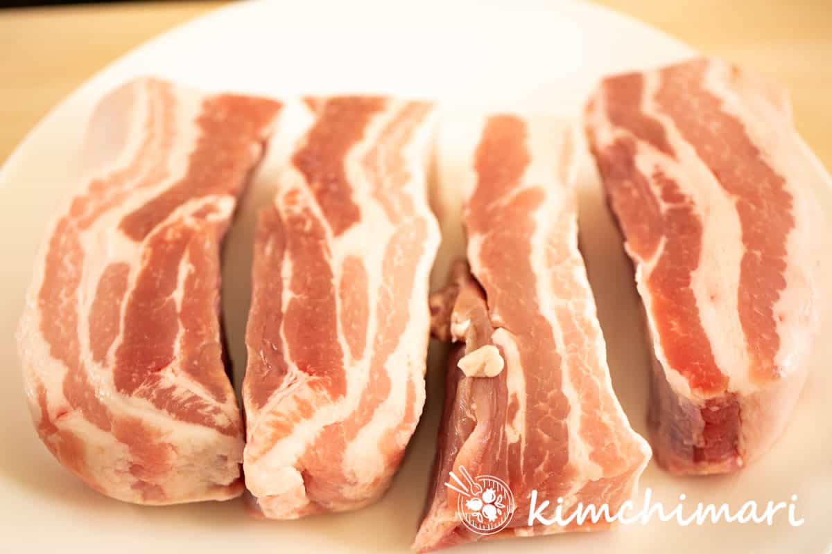 pork belly whole cuts before slicing laid out on white plate