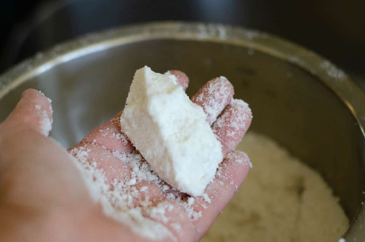 wet tteok flour mix shaped into log in hand