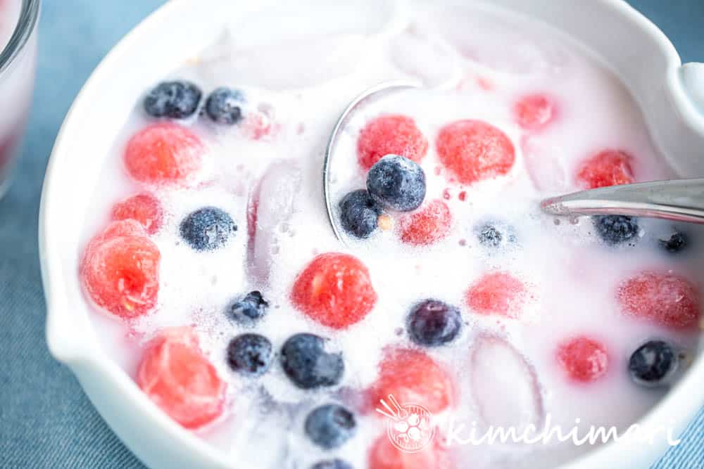korean watermelon punch with watermelon balls, blueberries in milky liquid with ice