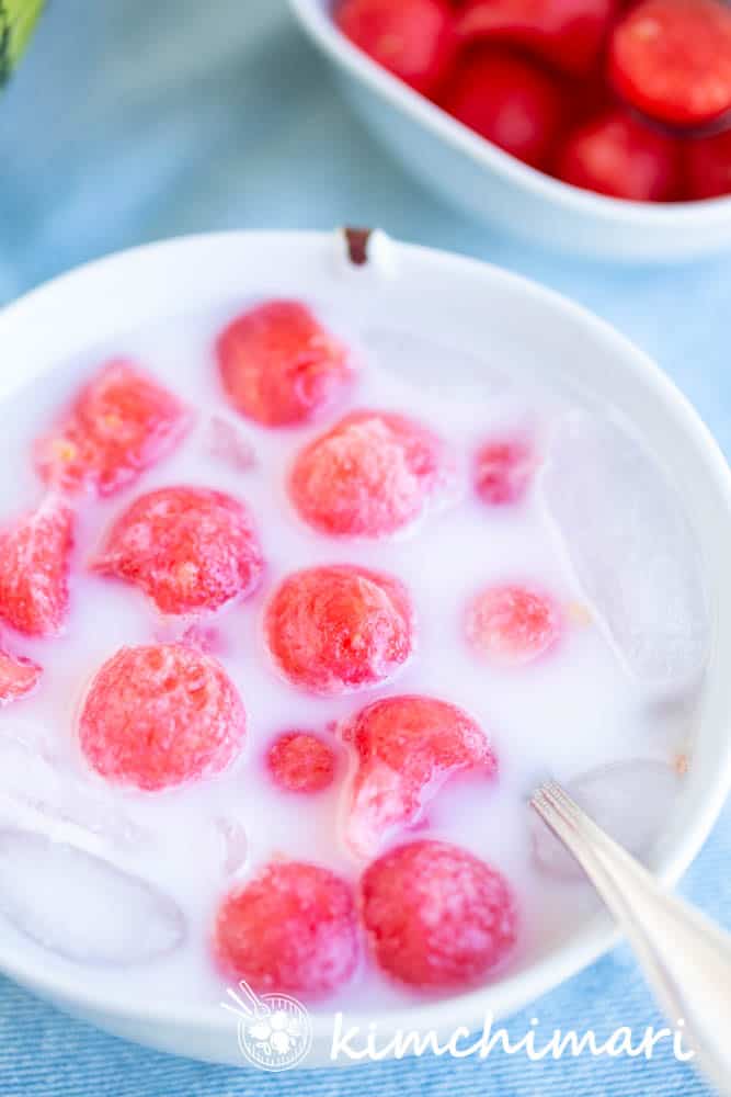 watermelon punch in white milky liquid in bowl with spoon