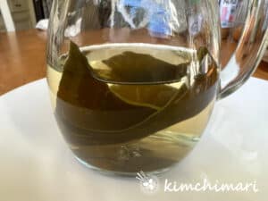 kelp soaking in water in a glass jug to make kelp broth
