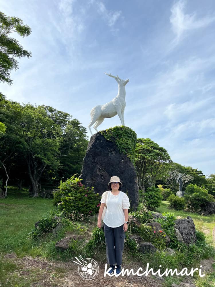 jinjoo posing in front of the highland rest area white deer statue