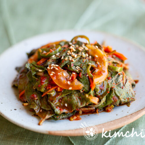 perilla kkaennip kimchi on light color plate on green background